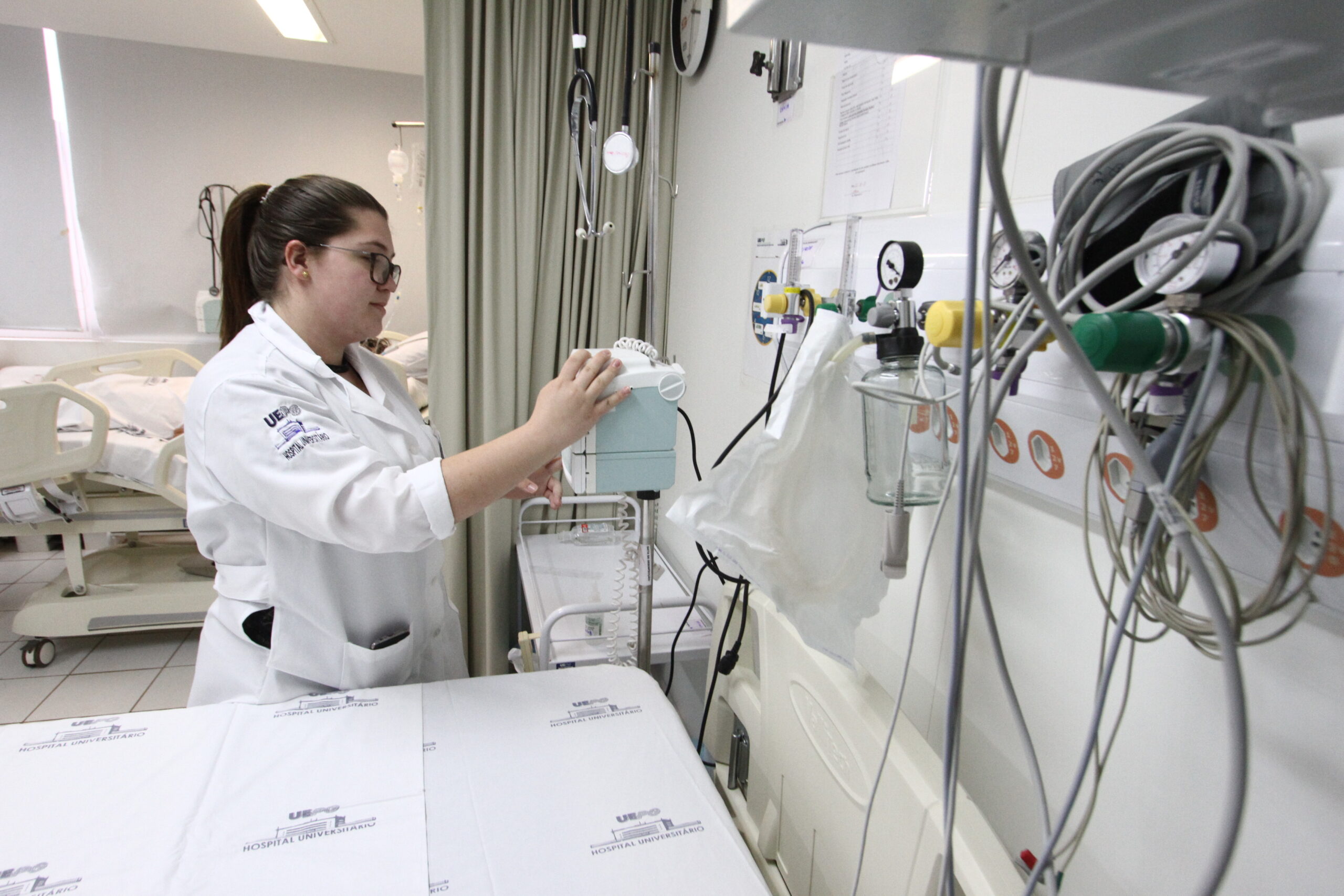 Foto de leito hospitalar com enfermeira dando atendimento