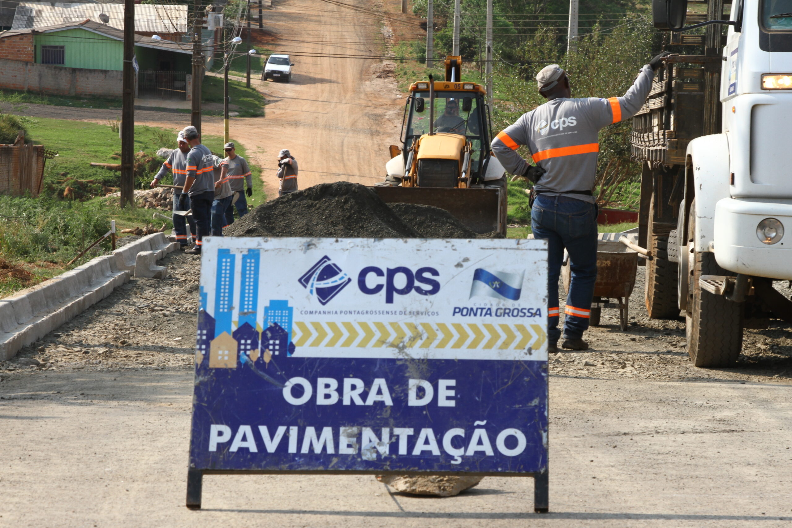 Foto de maquinário e servidores trabalhando em obra de pavimentação da Companhia Pontagrossense de Serviços - CPS