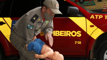 Foto do subtenente do Corpo de Bombeiros, Flávio Roberto Blum, orientando sobre como fazer a Manobra de Heimlich para salvar bebê vítima afogado