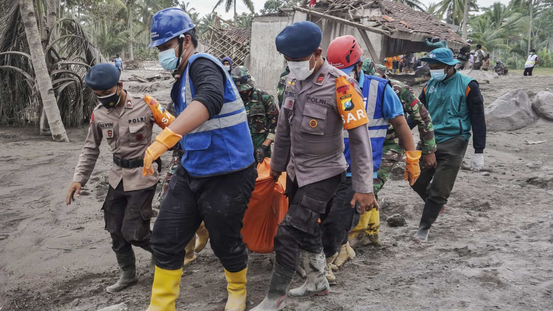 Bombeiros da Indonésia carregam um corpo após a retomada da erupção do vulcão.