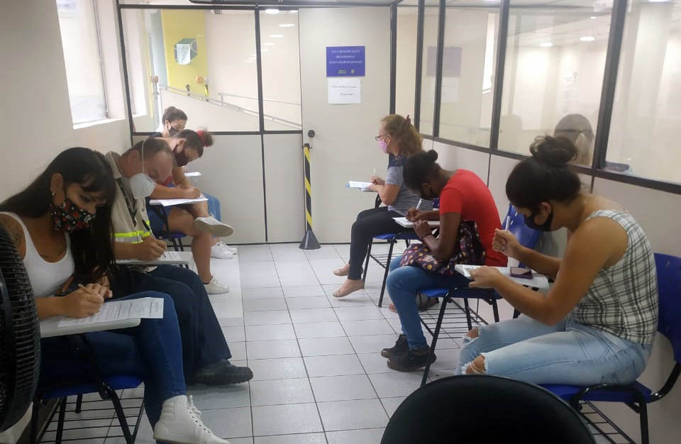 Foto de candidatos a emprego preenchendo formulários em sala da Agência do Trabalhador de Ponta Grossa