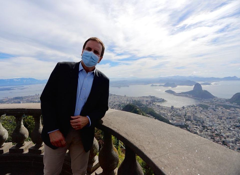 Foto do prefeito do Rio de Janeiro Eduardo Paes com paisagem de Copacabana ao fundo