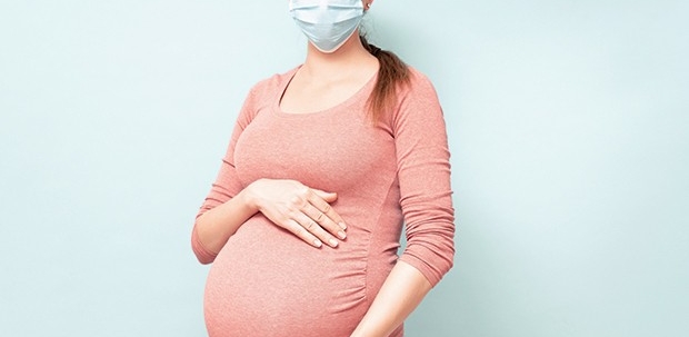 Foto de grávida com máscara, representando a flurona