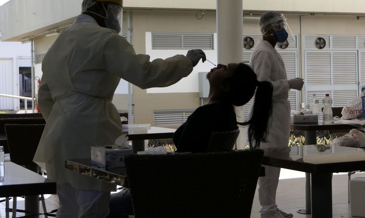 Foto de pessoa passando por procedimento de testagem para covid-19, com uso de cotonete