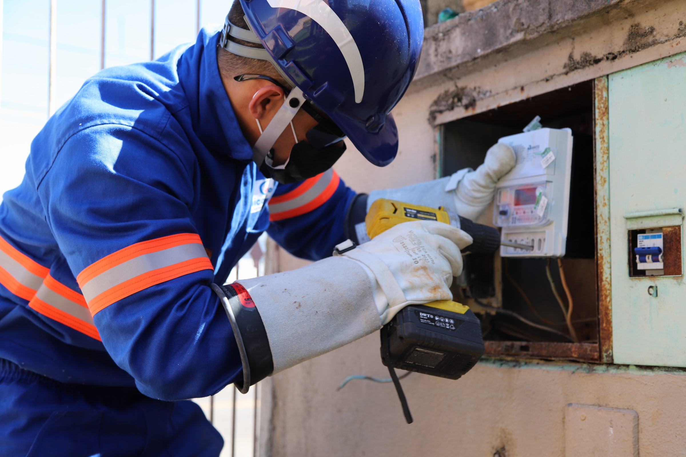 Foto de técnico da Copel instalando medidor digital de energia