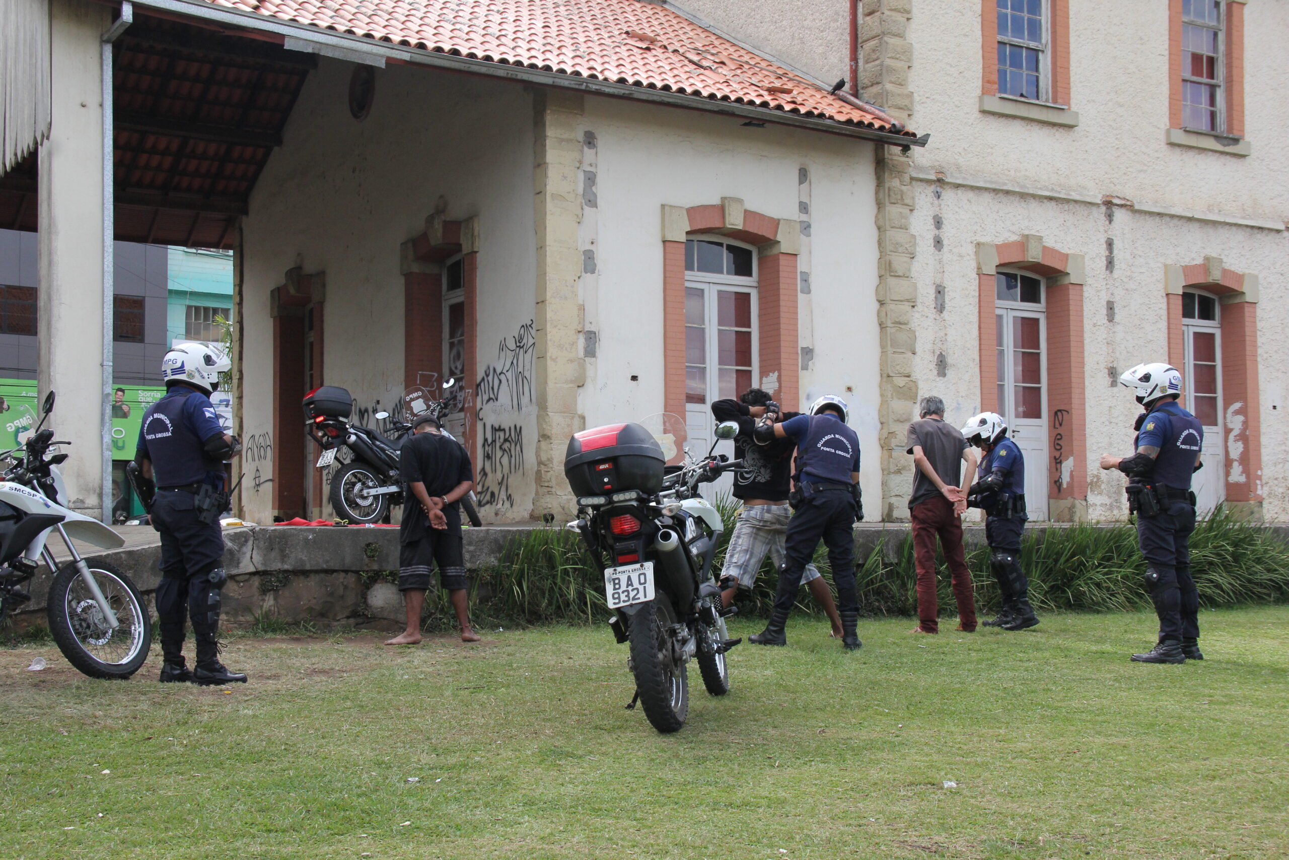 Foto da Guarda Civil Municipal de Ponta Grossa fazendo revista em suspeito junto à Estação Paraná