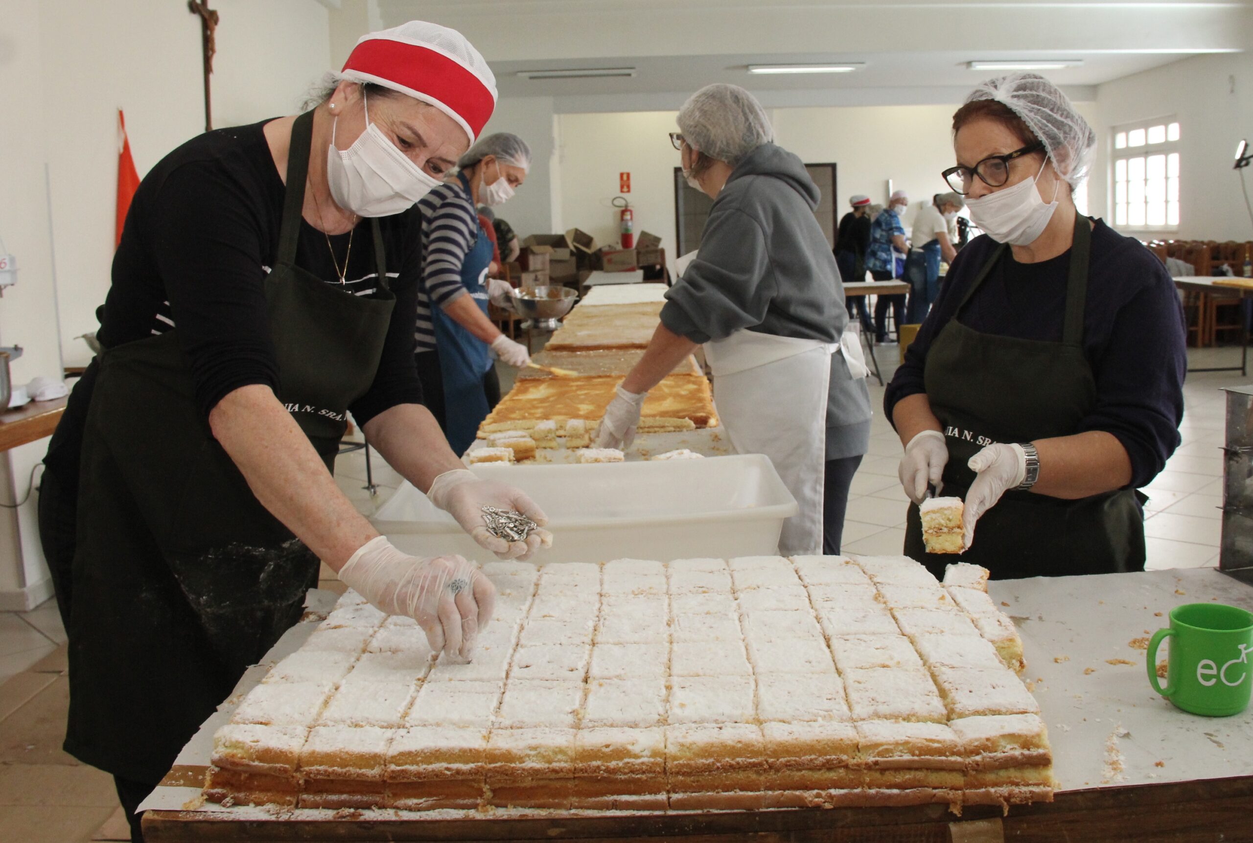 Foto de cozinheiras preparando o Bolo de Santo Antônio, na Paróquia do Rosário, em Ponta Grossa