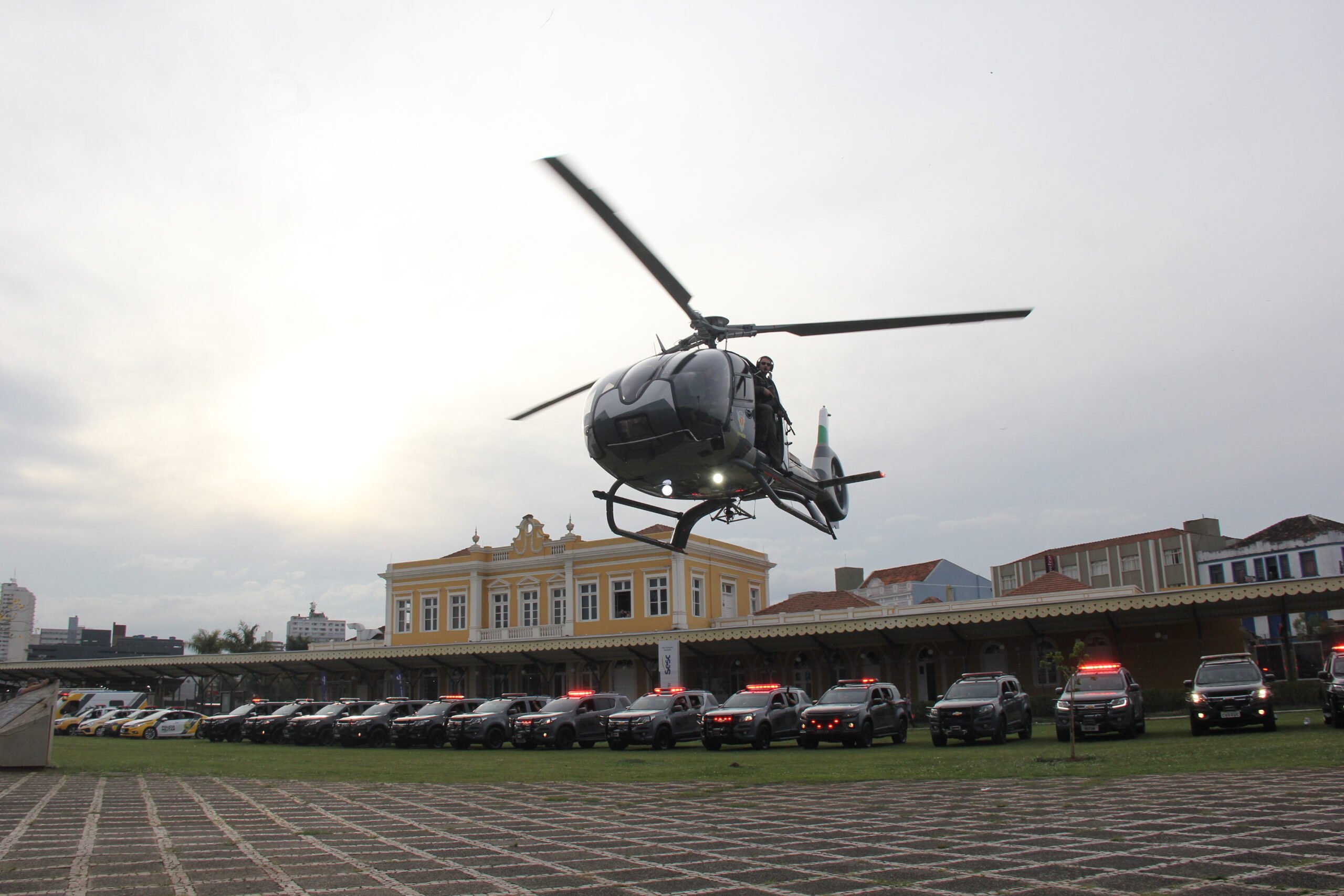 Foto de helicóptero da Polícia Militar do Paraná e viaturas diante da Estação Saudade, em Ponta Grossa