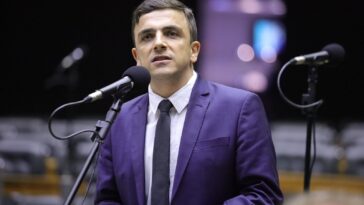 Deputado Federal Aliel Machado discursando em microfone