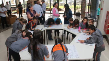 Crianças pintando ilustrações do mapa de Carambeí produzido pelo Diário dos Campos