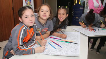 Crianças pintando o mapa do projeto Vamos Pintar Carambeí