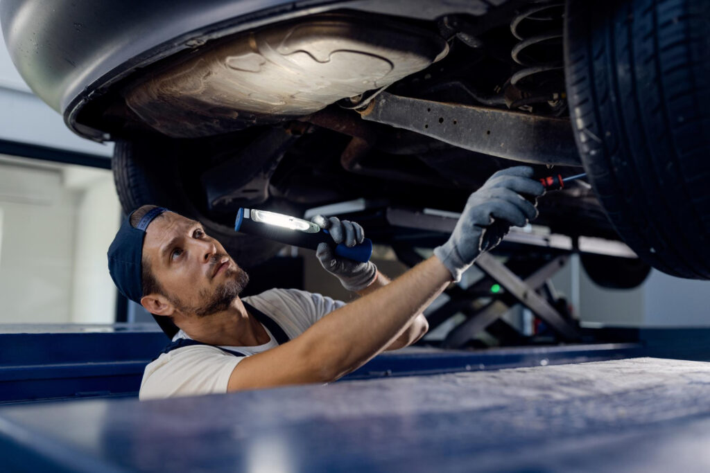 Mecânico mexendo embaixo de um carro