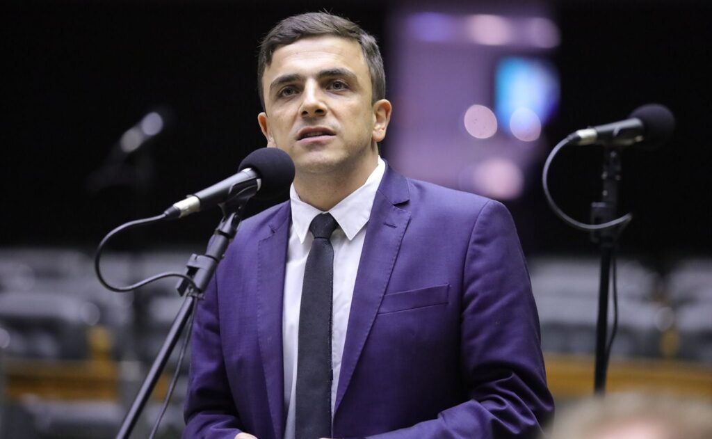 Deputado Federal Aliel Machado discursando em microfone