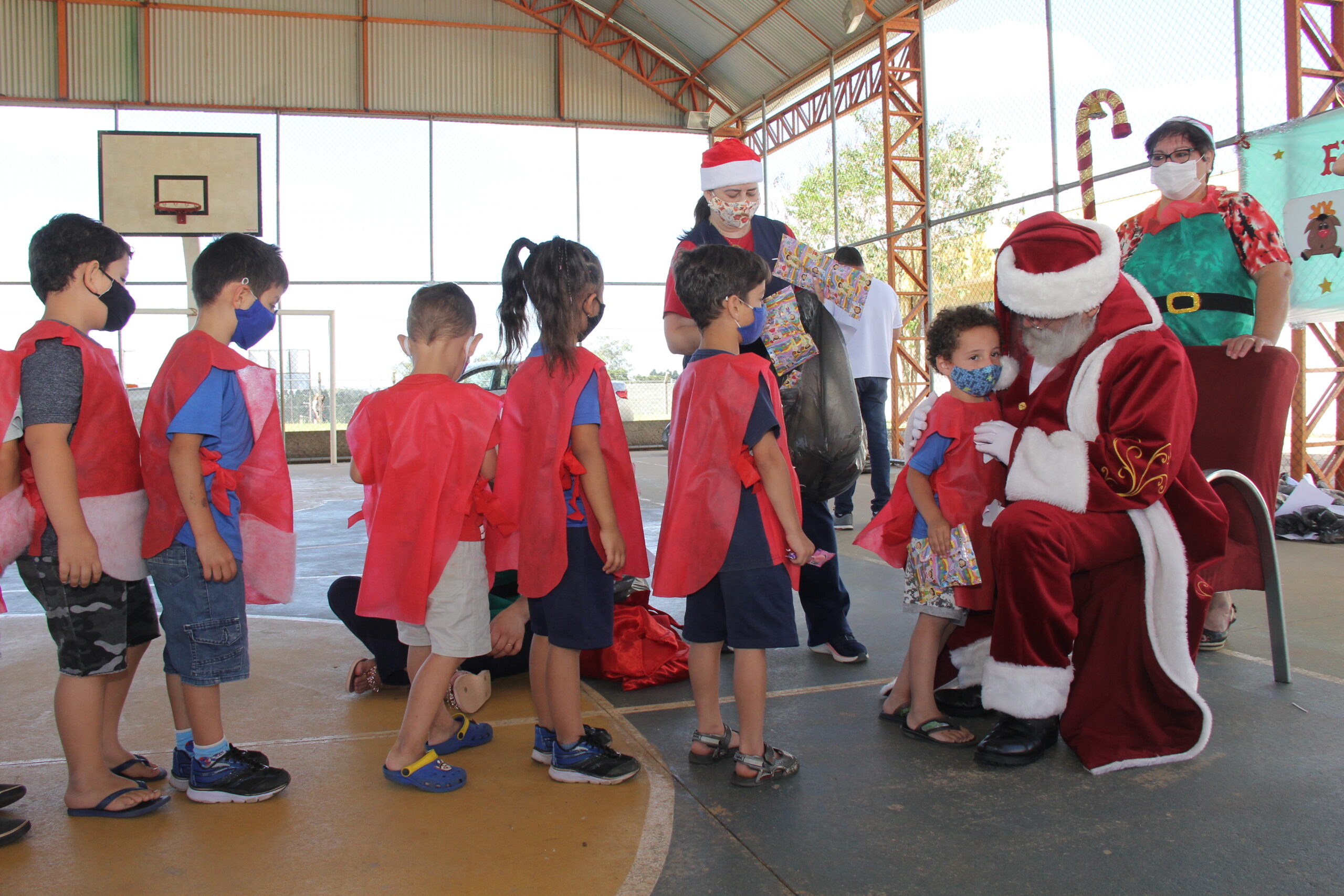 Crianças em apresentação de Natal recebendo o papai noel