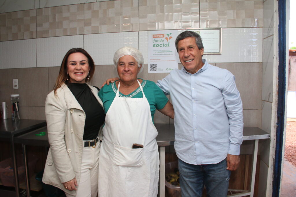 Gerente da agência do Sicredi no Bairro Cará-Cará, Elaine Mansani, Dona Cidinha e o empresário Álvaro Góes, abraçados na entrega do Fundo Social Sicredi à Casa da Sopa