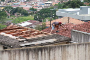 Morador troca telhas de casa atingida por temporal