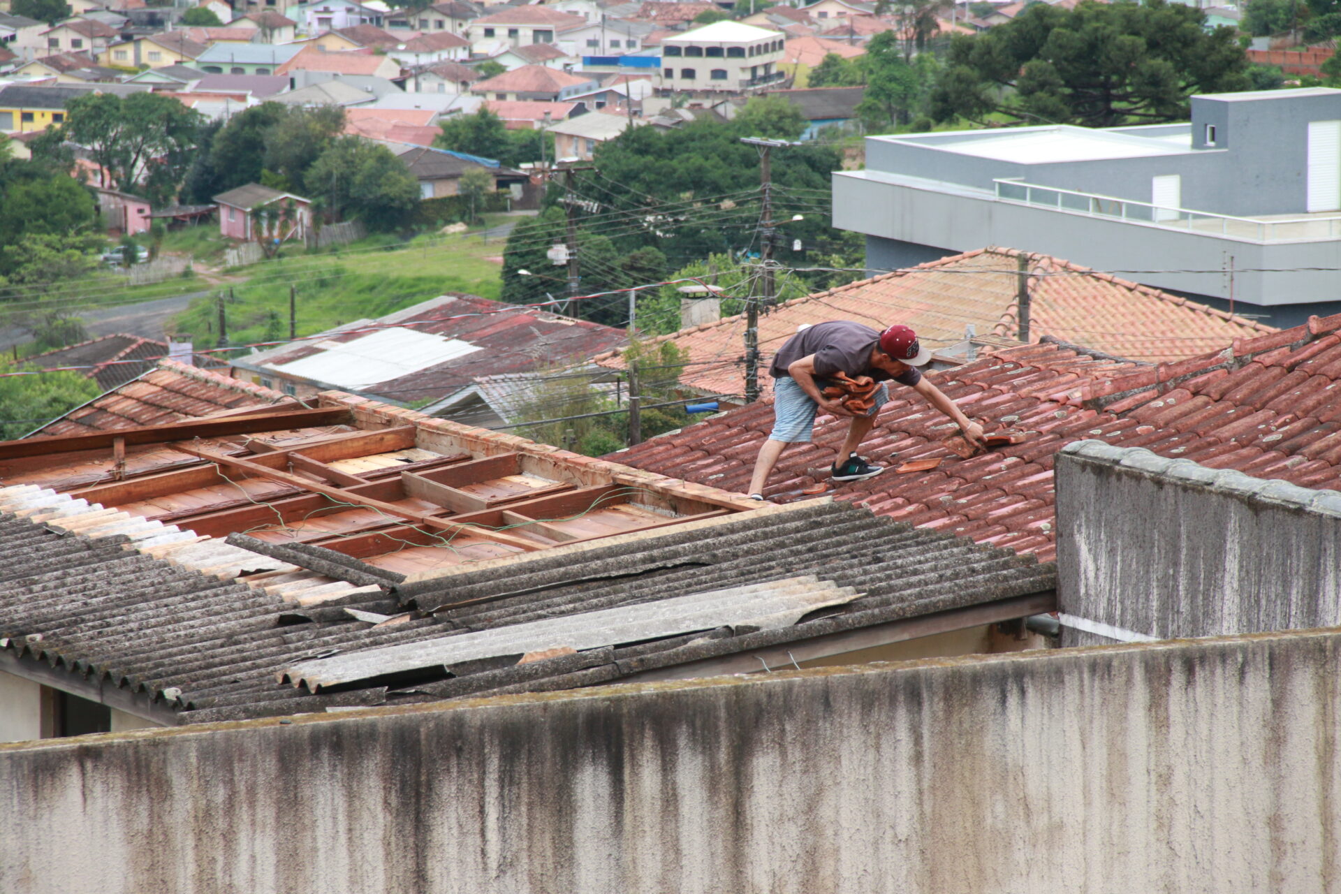 Morador troca telhas de casa atingida por temporal
