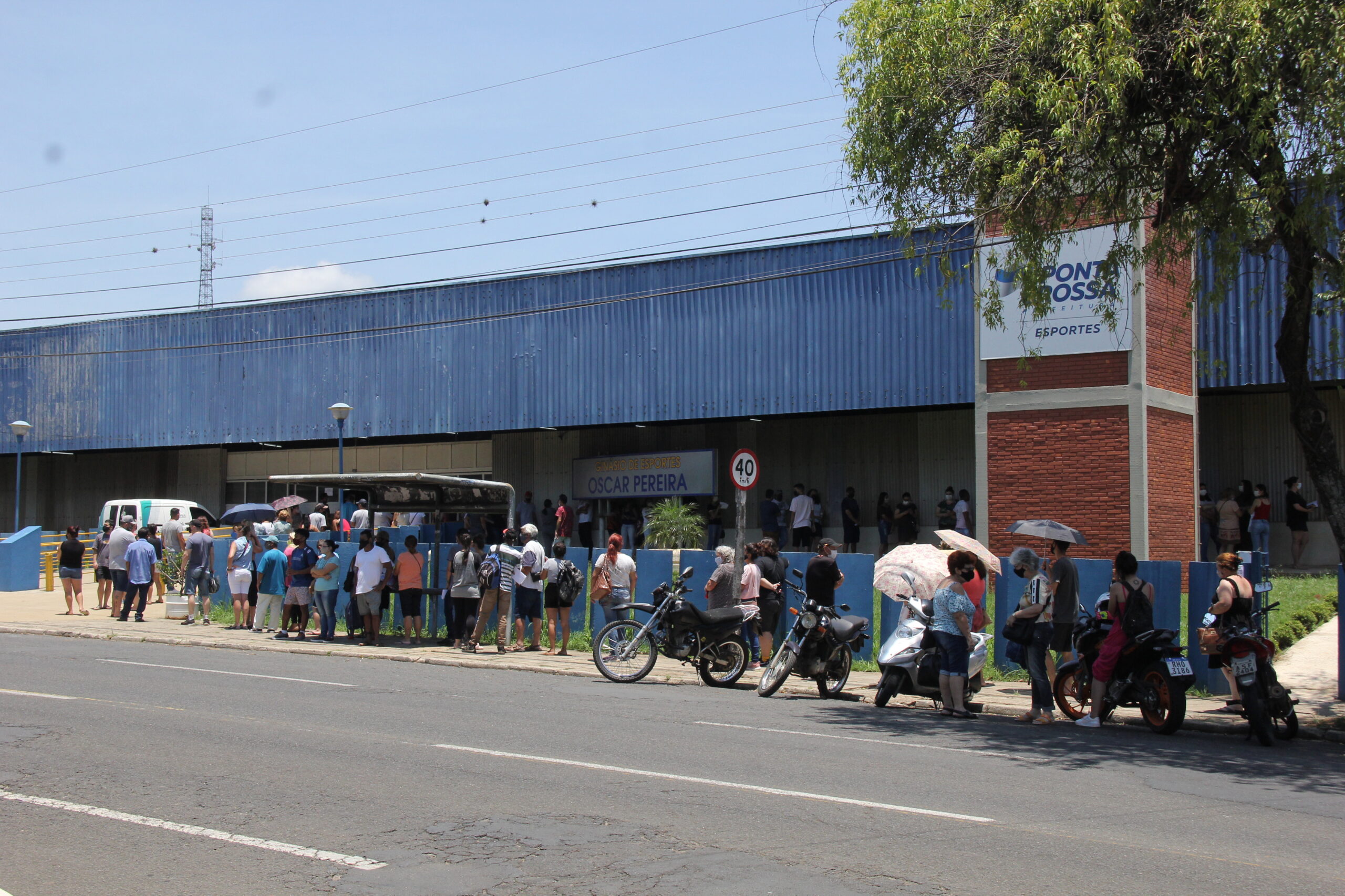 Foto de fila diante do Ginásio Oscar Pereira, o gripário de Ponta Grossa