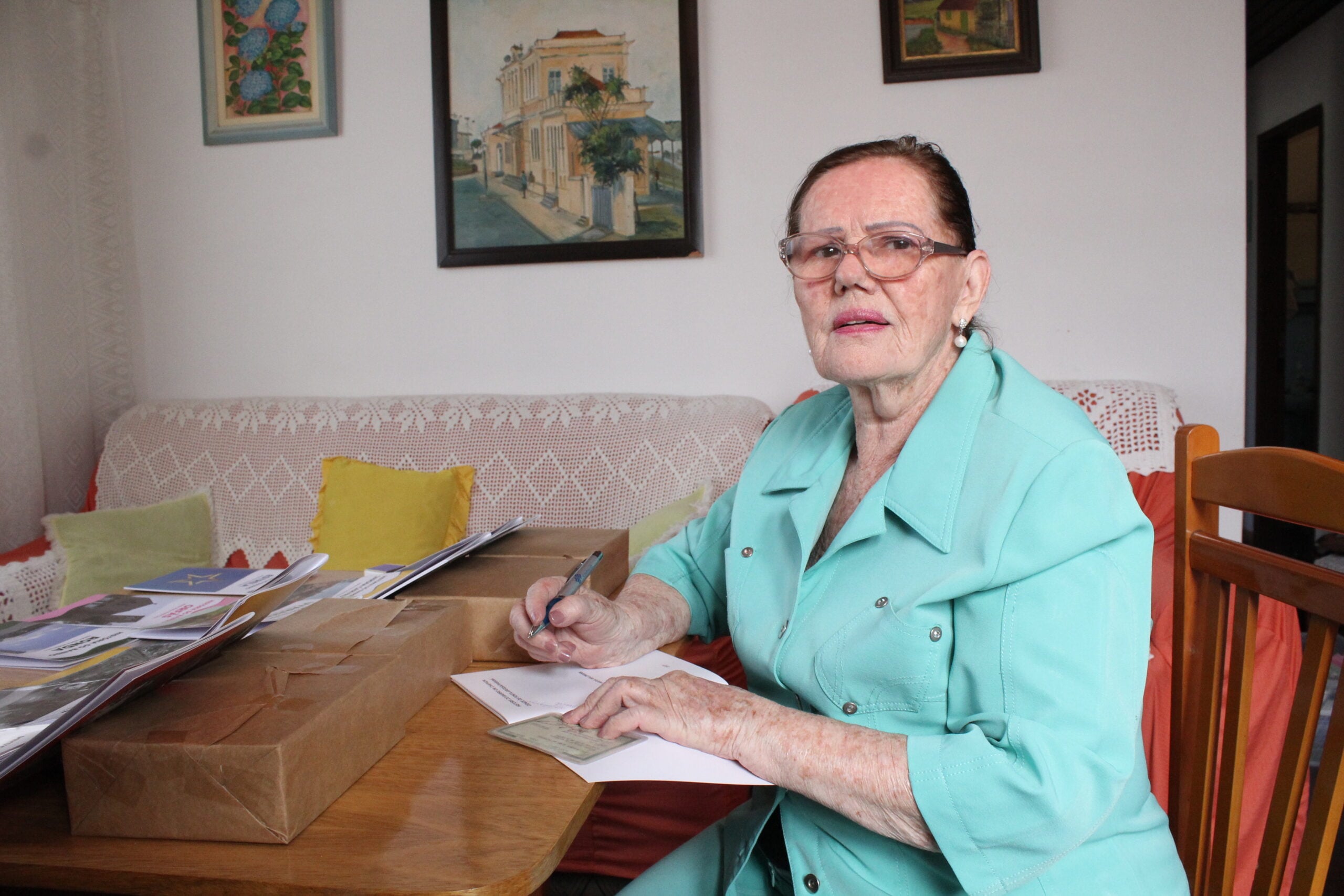 Foto da escritora Isolde Maria Waldmann, autografando um de seus livros