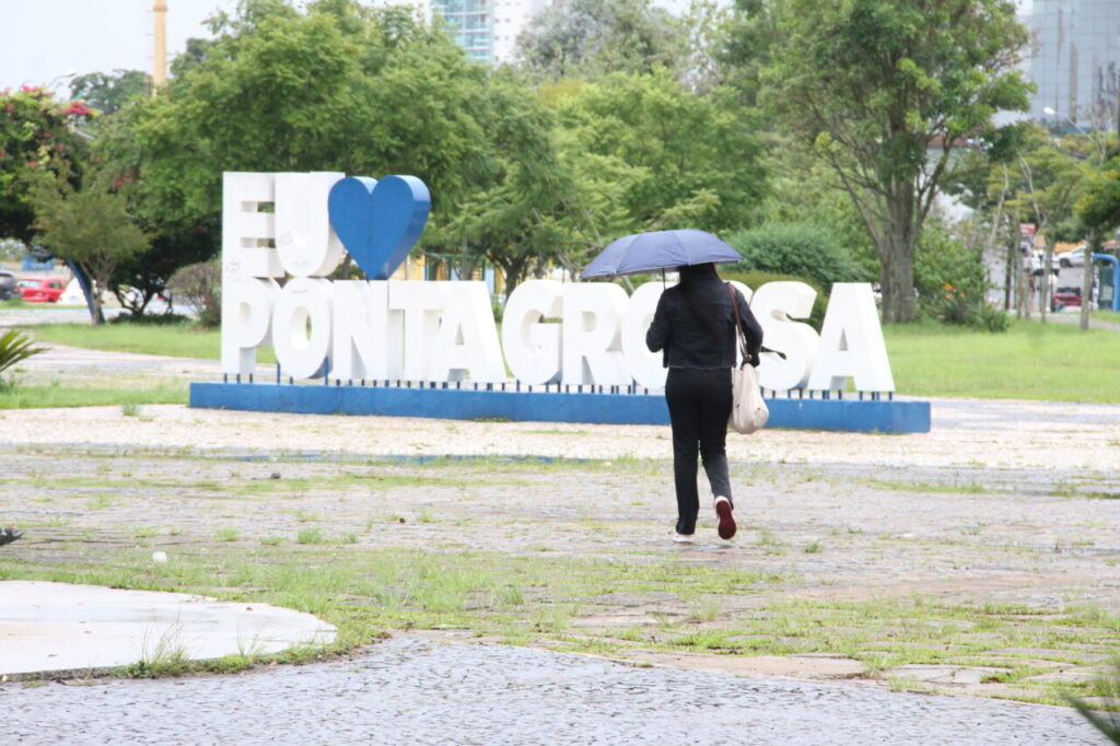 Mulher com guarda-chuva ilustra previsão do tempo de PG