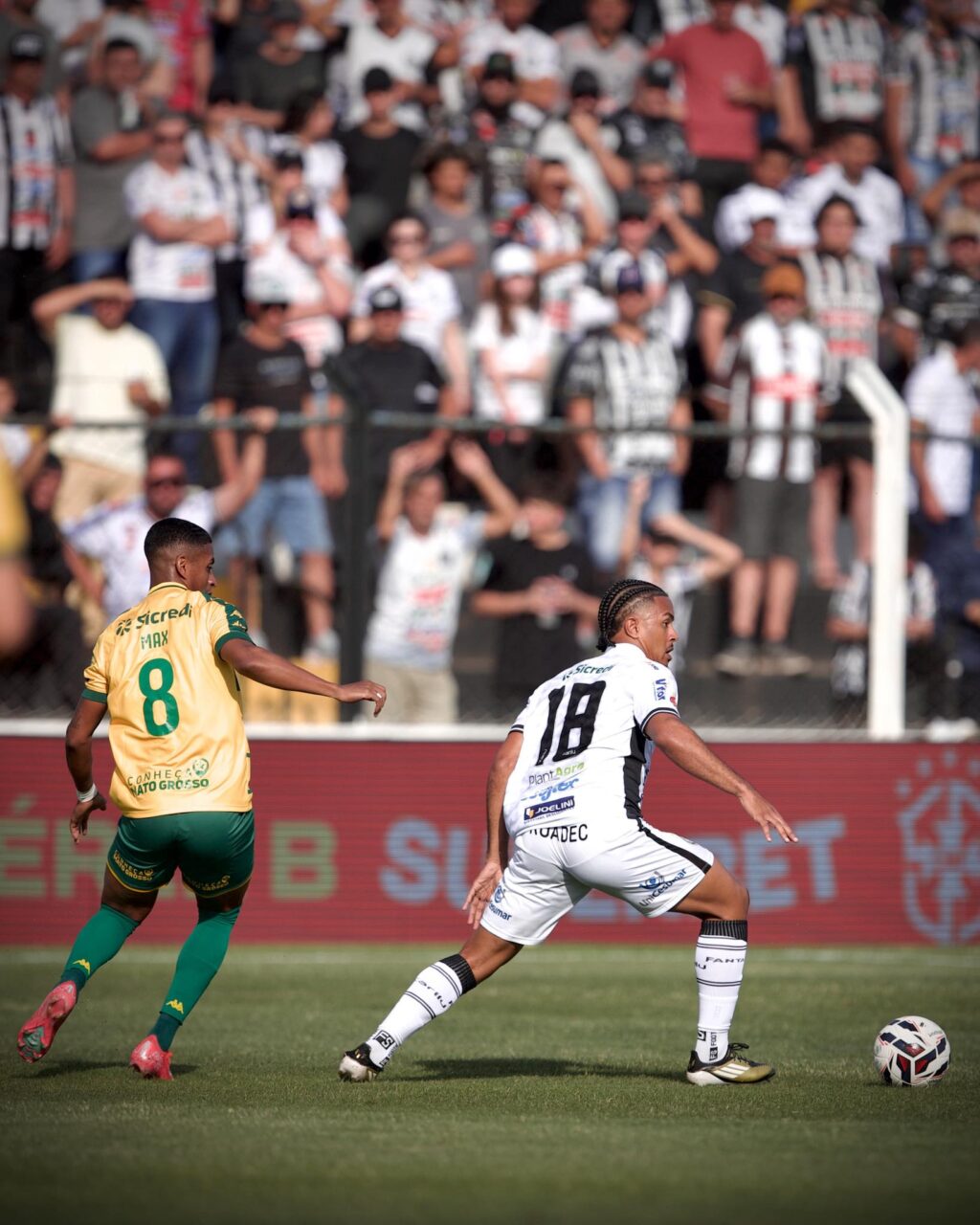 Jogador do Operário e do Cuiabá disputam bola.