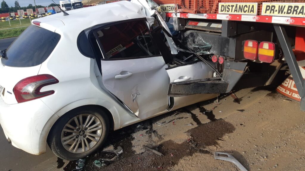 Foto de carro esmagado, em acidente ocorrido na BR-376, após impacto na traseira de caminhão