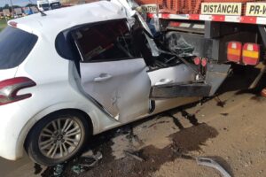 Foto de carro esmagado, em acidente ocorrido na BR-376, após impacto na traseira de caminhão
