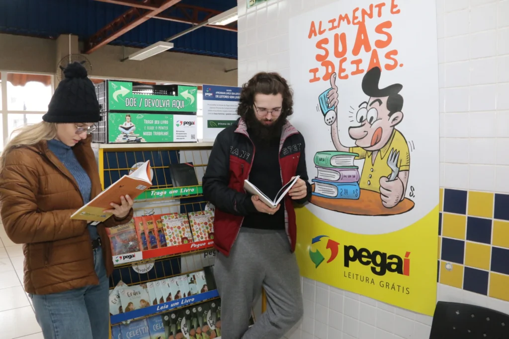 Leitores em uma estante do Pegaí Leitura Grátis