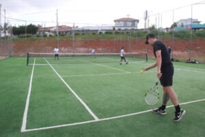 Tenista se prepara para sacar em jogo de duplas na quadra do Lago de Olarias.