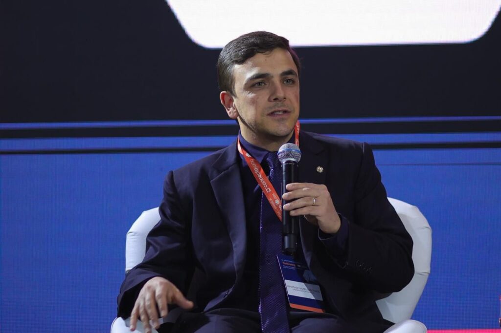 Aliel Machado segurando um microfone e discursando em evento.