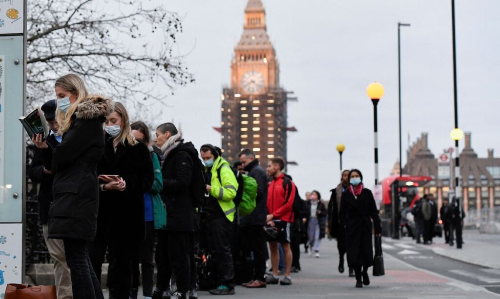 Foto de pessoas de máscara na inglaterra ilustrando a pandemia e a variante ômicron