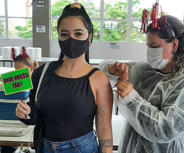Enfermeira aplica a vacina contra a covid-19 em uma jovem.