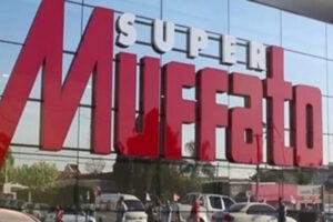 Logotipo do Grupo Muffato em loja com fundo espelhado.