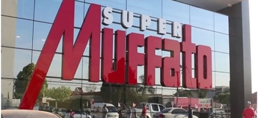Logotipo do Grupo Muffato em loja com fundo espelhado.
