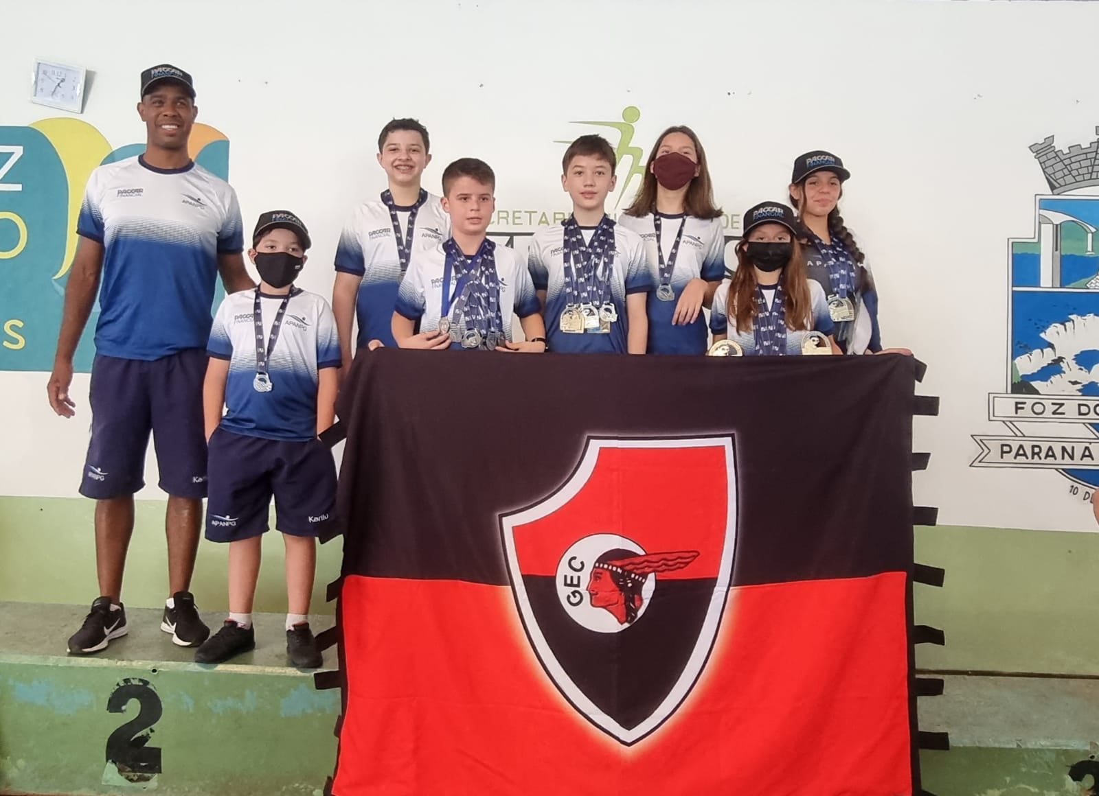 Nadadores de Ponta Grossa seguram a bandeira do Guarani Esporte Clube no pódio