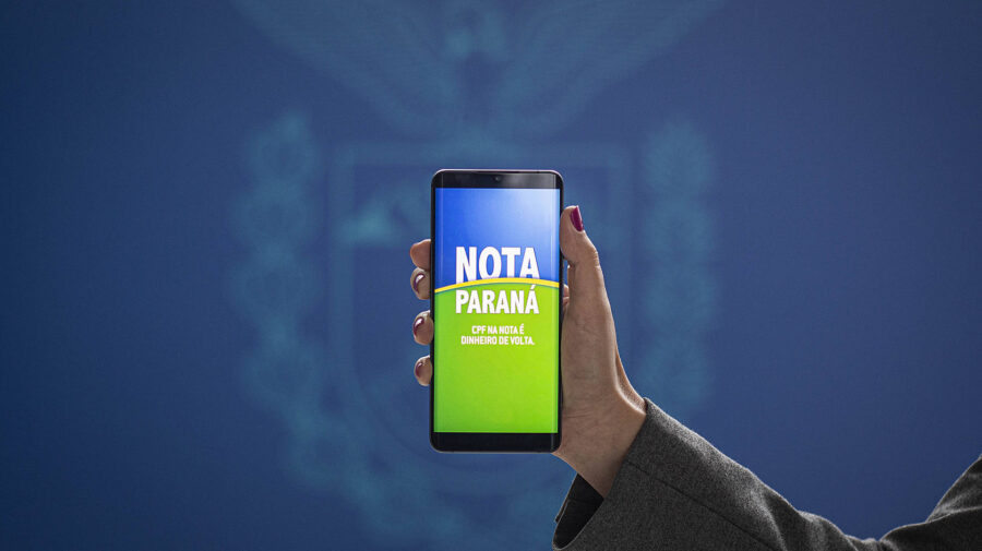 Uma pessoa segurando um celular com a mensagem Nota Paraná na tele.