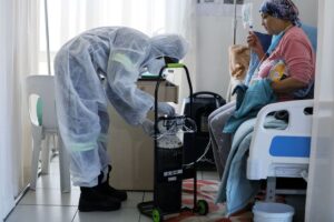 Enfermeira regulando oxigênio de paciente com sintomas da variante Ômicron