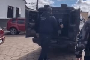 Policiais abrem viatura para retirar o preso do camburão