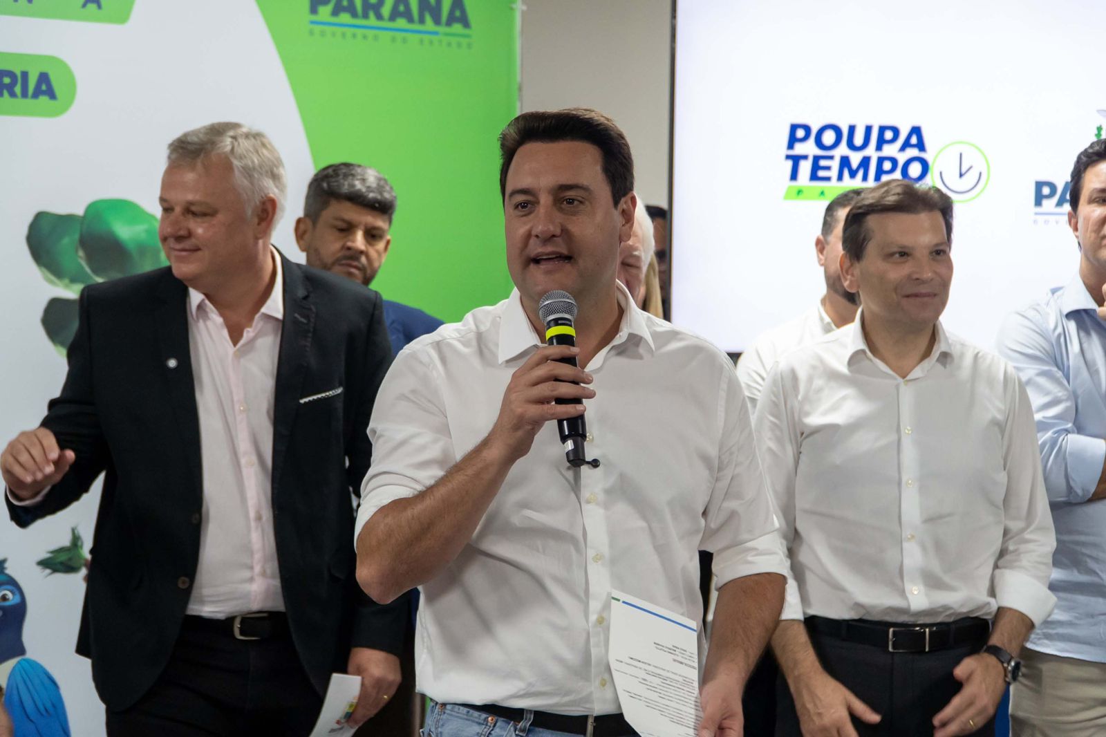 Governador do Paraná, Ratinho Junior, falando e segurando o microfone