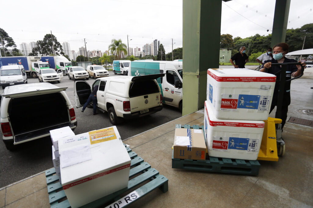 Foto de funcionários do Cemepar carregando vacinas contra a Covid 19, para as 22 regionais de saúide do Paraná
