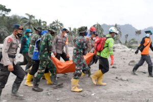 Bombeiros da Indonésia carregam um corpo após a retomada da erupção do vulcão.