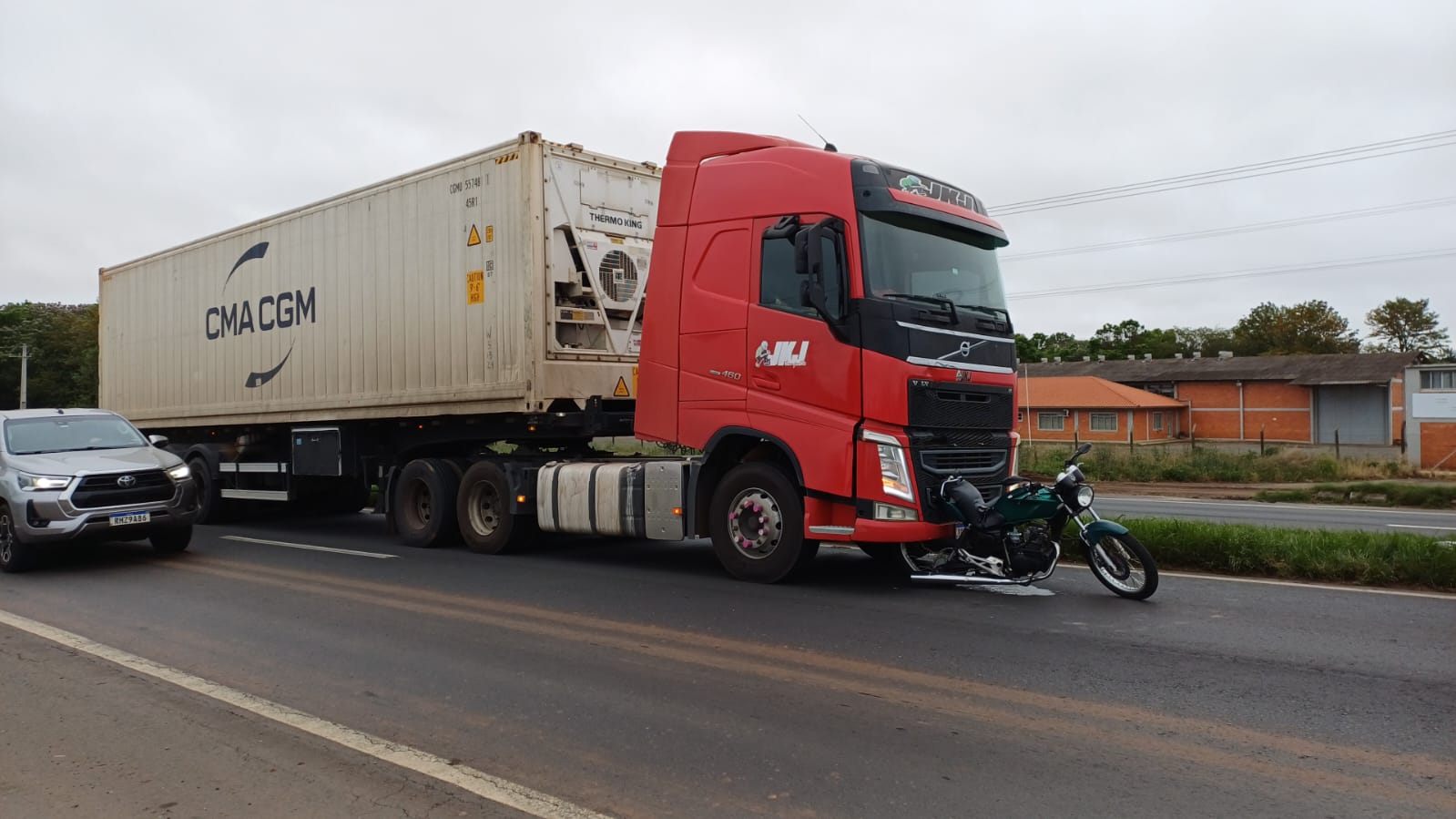 Moto ficou presa no parachoque do caminhão