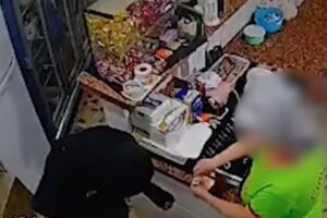 Funcionária da pizzaria entrega o dinheiro para o assaltante