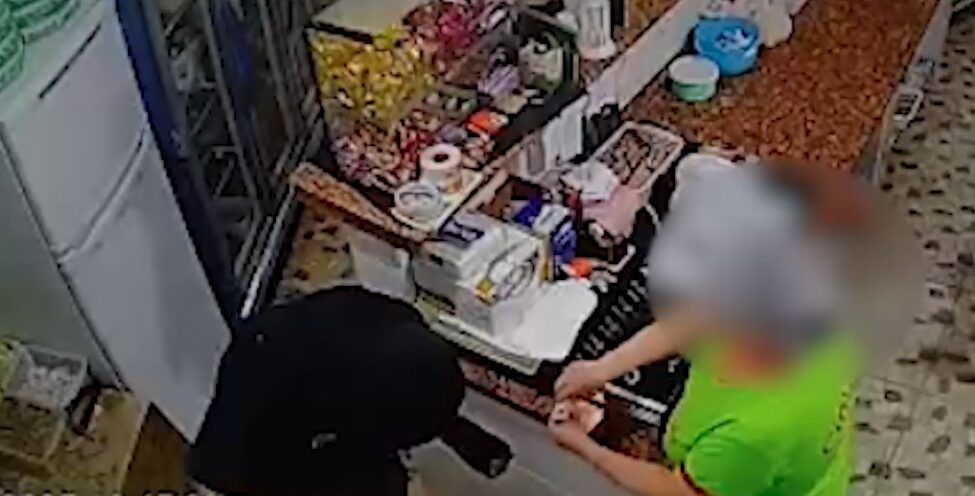 Funcionária da pizzaria entrega o dinheiro para o assaltante
