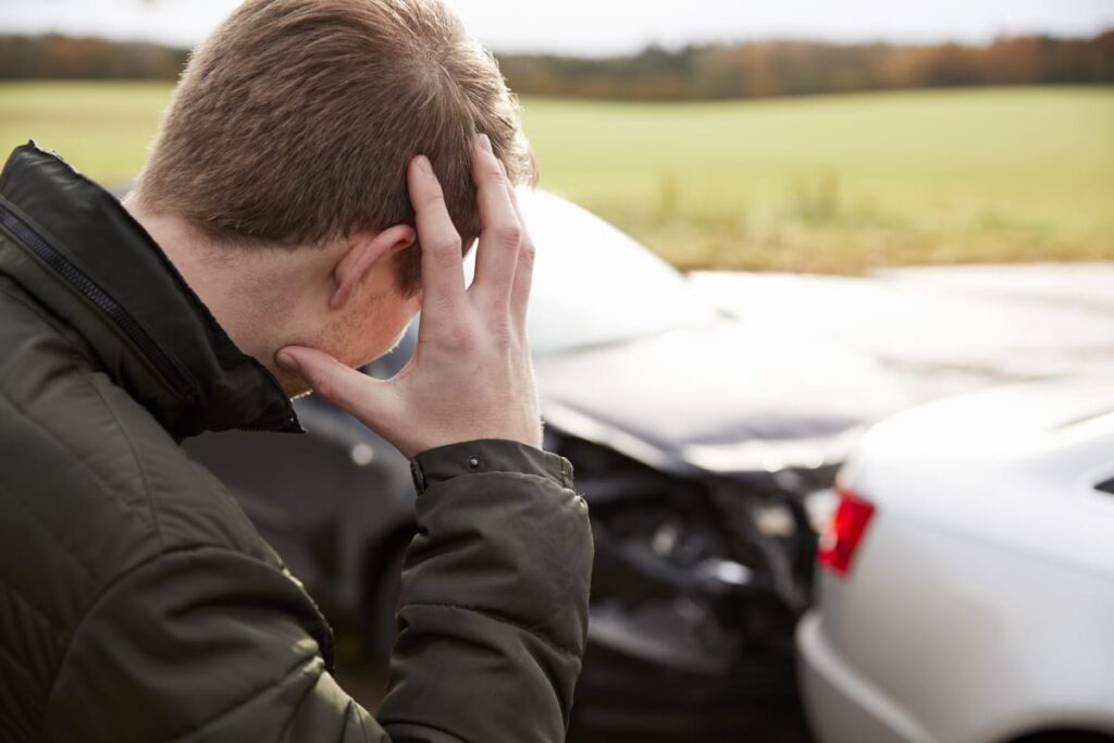 Frustrated Man With Damaged Car After Accident