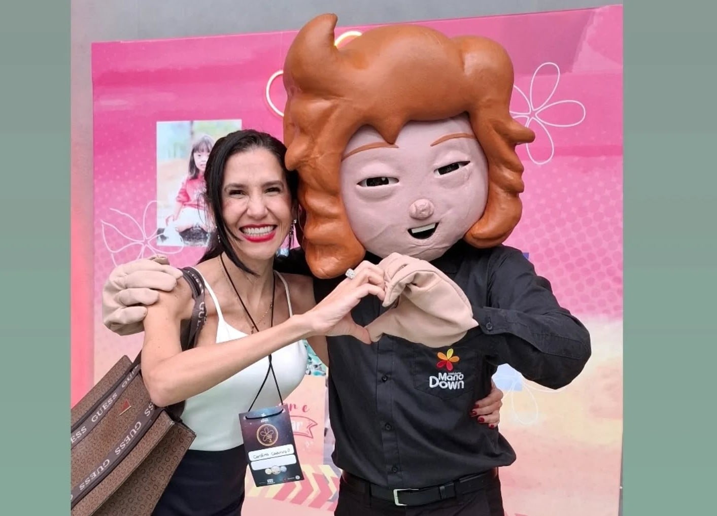 Carolina Capuruço, ao lado de pessoa vestida com fantasia que representa pessoa com Síndrome de Donw