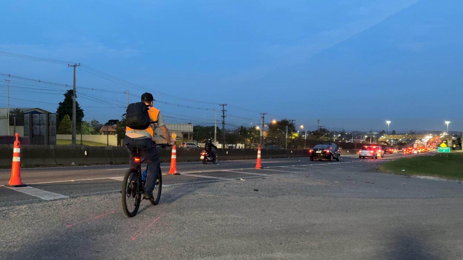 Ciclista à margem da rodovia