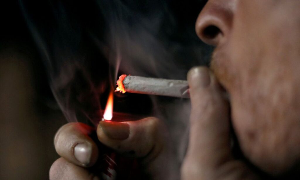 Pessoa acedendo um cigarro