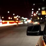 Foto noturna do lado da janela do motorista, registra luzes noturnas na cidade