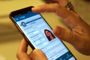 Mãos seguram smartphone em que aparece o e-título na tela